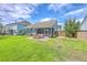 Landscaped backyard with screened patio, stone patio, and lush lawn at 359 Whispering Breeze Ln, Summerville, SC 29486
