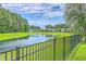 Peaceful backyard with a picturesque pond view and a wrought iron fence at 359 Whispering Breeze Ln, Summerville, SC 29486