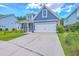 Beautiful two-story home with blue siding, a large garage, an American flag, and a lush green lawn at 359 Whispering Breeze Ln, Summerville, SC 29486