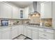 Updated kitchen showcasing stainless vent hood, granite countertops, and classic white cabinetry at 359 Whispering Breeze Ln, Summerville, SC 29486