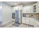 Well-lit kitchen featuring stainless appliances, white cabinets and tile backsplash at 359 Whispering Breeze Ln, Summerville, SC 29486