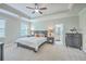 Serene main bedroom with tray ceiling, soft lighting, and a glimpse into the ensuite bathroom at 359 Whispering Breeze Ln, Summerville, SC 29486