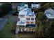 Aerial perspective of the luxury home highlighting multiple decks, a pool, and manicured landscaping at 4001 Palm Blvd, Isle of Palms, SC 29451