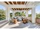 Covered outdoor living space featuring comfortable seating, stylish décor, and a glimpse of lush greenery at 4001 Palm Blvd, Isle of Palms, SC 29451