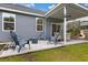 Well-maintained backyard with a covered patio, modern seating, a fire pit, and green grass at 404 Omaha Dr, Moncks Corner, SC 29461