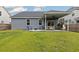 Lush backyard featuring a covered patio, outdoor seating, a fire pit area, and a well-maintained lawn at 404 Omaha Dr, Moncks Corner, SC 29461