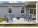 Beautiful backyard with a stone fire pit area, comfortable seating, green grass, and a house in the background at 404 Omaha Dr, Moncks Corner, SC 29461