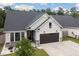 Beautiful single-Gathering home featuring gray vinyl siding, stone accents, dark garage door, and manicured landscaping at 404 Omaha Dr, Moncks Corner, SC 29461
