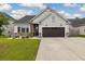 Charming single-Gathering home featuring stone accents, a dark two-car garage, and a spacious front yard at 404 Omaha Dr, Moncks Corner, SC 29461