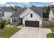 Beautiful single-Gathering home with a spacious driveway, gray vinyl siding, dark garage door, and manicured landscaping at 404 Omaha Dr, Moncks Corner, SC 29461