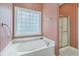 Bathroom features a glass enclosed shower, and a separate soaking tub under a glass block window at 416 Prestwick Ct, Summerville, SC 29483