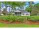 Charming exterior view of the home with screened porch, framed by lush landscaping and a verdant lawn at 416 Prestwick Ct, Summerville, SC 29483