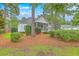 Charming home with a screened porch, surrounded by lush landscaping, pine trees, and a well-maintained yard at 416 Prestwick Ct, Summerville, SC 29483