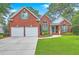 Charming two-story red brick home with a well-manicured lawn, two-car garage and inviting curb appeal at 416 Prestwick Ct, Summerville, SC 29483
