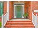 Inviting brick front porch featuring a green door adorned with a wreath and white railing on the steps at 416 Prestwick Ct, Summerville, SC 29483