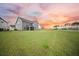 Spacious backyard with a view of the home's exterior, set against a colorful evening sky at 436 Rowley Ln, Summerville, SC 29486