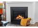 Cozy fireplace with a black surround and a basket with a yellow throw blanket at 436 Rowley Ln, Summerville, SC 29486