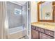 Bathroom featuring a tub with shower, granite vanity, tile floor and a window for natural light at 4403 Sea Forest Dr, Kiawah Island, SC 29455