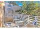 Outdoor patio with wicker furniture, cushions, table, railing, and views of trees and nearby buildings at 4403 Sea Forest Dr, Kiawah Island, SC 29455