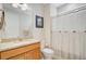 Well-lit bathroom features a vanity with a granite countertop and a shower with a striped curtain at 5078 Song Sparrow Way, Summerville, SC 29483