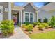 Inviting front entrance with glass paneled door and lush landscaping at 5078 Song Sparrow Way, Summerville, SC 29483