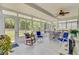 Bright sunroom with tile floors, ceiling fan, dining table, and rocking chair at 5078 Song Sparrow Way, Summerville, SC 29483