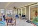 Covered porch features tile floors, ceiling fan, and multiple windows for natural light at 5078 Song Sparrow Way, Summerville, SC 29483