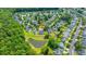 An aerial view of the neighborhood showcases lush landscaping, nearby trees, and the pond at 5128 Thornton Dr, Summerville, SC 29485