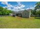 Expansive well-manicured backyard with a tan house and screened-in back patio at 5128 Thornton Dr, Summerville, SC 29485