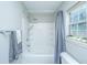 Bright bathroom featuring a shower-tub combo and a window with decorative plants at 5128 Thornton Dr, Summerville, SC 29485