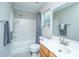 Clean bathroom showcasing a tub with shower, wood vanity, and a bright window at 5128 Thornton Dr, Summerville, SC 29485