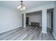 Open-concept living area with modern flooring, neutral walls, and a stylish chandelier at 5128 Thornton Dr, Summerville, SC 29485