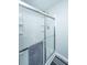 A bright white shower with sliding glass door and shampoo and soap shelves at 5128 Thornton Dr, Summerville, SC 29485