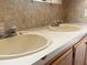 Bathroom double vanity with two sinks and a light beige countertop, featuring two faucets at 513 Pauline Dr, Bonneau, SC 29431