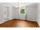 Open dining room adjacent to the kitchen with hardwood floors, chandelier, and backyard view at 513 Pauline Dr, Bonneau, SC 29431