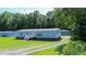 Charming one-story home with light blue siding, a metal roof, and a well-maintained front lawn at 513 Pauline Dr, Bonneau, SC 29431