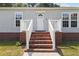 Close-up of home's entrance featuring brick steps, white railing, and a decorative front door with the house number 513 at 513 Pauline Dr, Bonneau, SC 29431