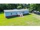 Front view of home with inviting white stairs and a well-manicured lawn at 513 Pauline Dr, Bonneau, SC 29431
