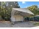 View of the garage featuring a metal roof and a roll-up garage door with a gravel driveway at 513 Pauline Dr, Bonneau, SC 29431