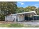 View of a functional metal outbuilding with two garage doors, side door, and a covered parking area at 513 Pauline Dr, Bonneau, SC 29431