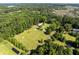 Expansive wooded property with a horse barn, paddock, and fenced training ring with solar panels nearby at 6434 Saint Anthony Dr, Meggett, SC 29449
