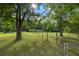 Green lawn with mature trees and a split rail fence enclosing the property at 6434 Saint Anthony Dr, Meggett, SC 29449