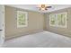This bedroom features two windows, neutral walls, neutral carpet, and a ceiling fan at 6434 Saint Anthony Dr, Meggett, SC 29449