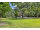 Charming two-story home with a screened porch, surrounded by mature trees and a lush green lawn at 6434 Saint Anthony Dr, Meggett, SC 29449