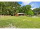 Well-maintained horse barn with stalls and fenced paddock in a lush, grassy area at 6434 Saint Anthony Dr, Meggett, SC 29449