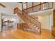 Wooden staircase leading to a second-floor balcony overlooking the living room at 6434 Saint Anthony Dr, Meggett, SC 29449