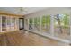 Enclosed sunroom with hardwood floors, fan, and walls of windows overlooking the backyard at 6434 Saint Anthony Dr, Meggett, SC 29449