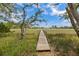Scenic wooden walkway stretches through a lush marsh, leading to a tranquil waterfront retreat at 6434 Saint Anthony Dr, Meggett, SC 29449