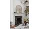 Elegant fireplace with a black stone surround, topped with a decorative mirror and complemented by stylish decor at 71 E Bay St, Charleston, SC 29401