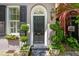 Charming front door with black shutters, surrounded by manicured greenery and a decorative window box at 71 E Bay St, Charleston, SC 29401